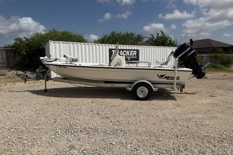 The Image of 2012 Mako 18 LTS boat with Mercury engine on a trailer, parked outdoors. - 0