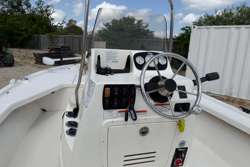 Slide: The Image of 2012 Mako 18 LTS boat console with steering wheel and control panel. - 17
