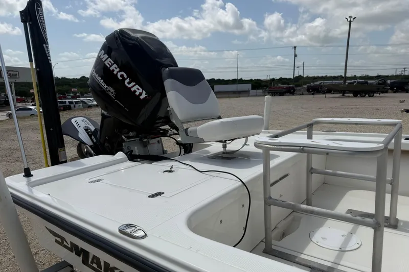 Slide: The Image of 2012 Mako 18 LTS boat with Mercury outboard motor, docked under a cloudy sky. - 8
