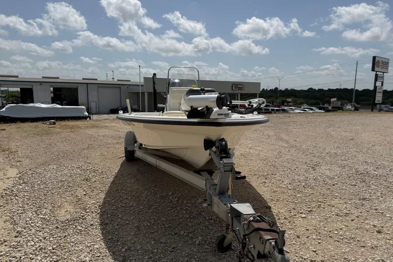 Slide: The Image of 2012 Mako 18 LTS boat on trailer in outdoor dealership lot under cloudy sky. - 7