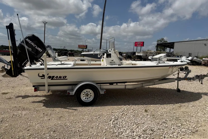 Slide: The Image of 2012 Mako 18 LTS boat on trailer, parked outdoors under cloudy sky. - 5