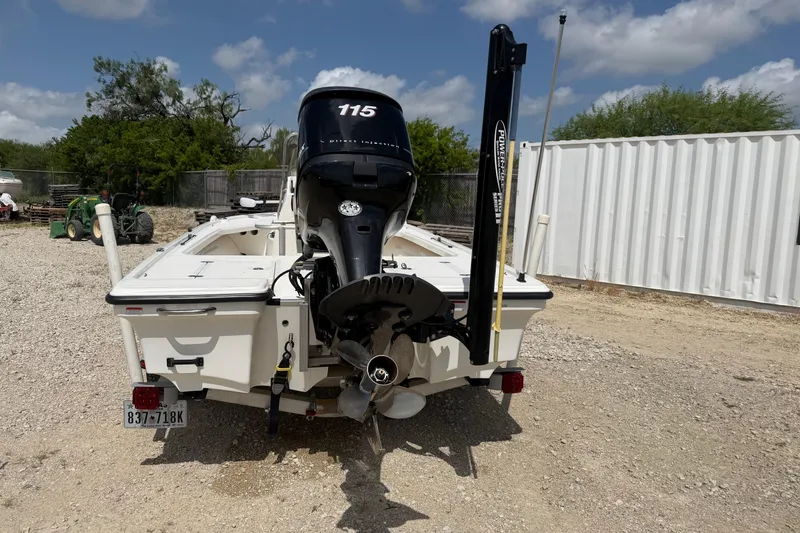 Slide: The Image of 2012 Mako 18 LTS boat with outboard motor, parked on gravel, under a partly cloudy sky. - 3