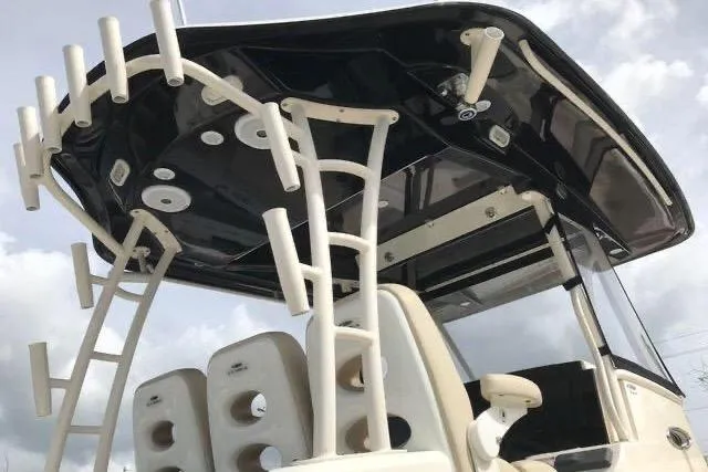 Slide: The Image of 2016 Cobia 344 Center Console boat with rod holders and sleek black canopy. - 4