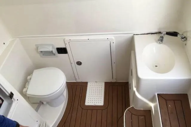 Slide: The Image of 2016 Cobia 344 Center Console boat bathroom with toilet and sink. - 13