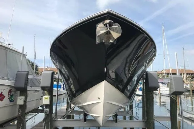 Slide: The Image of 2016 Cobia 344 Center Console boat on lift at marina. - 3