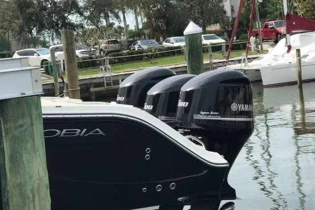 Slide: The Image of 2016 Cobia 344 Center Console boat with triple Yamaha engines docked at marina. - 18