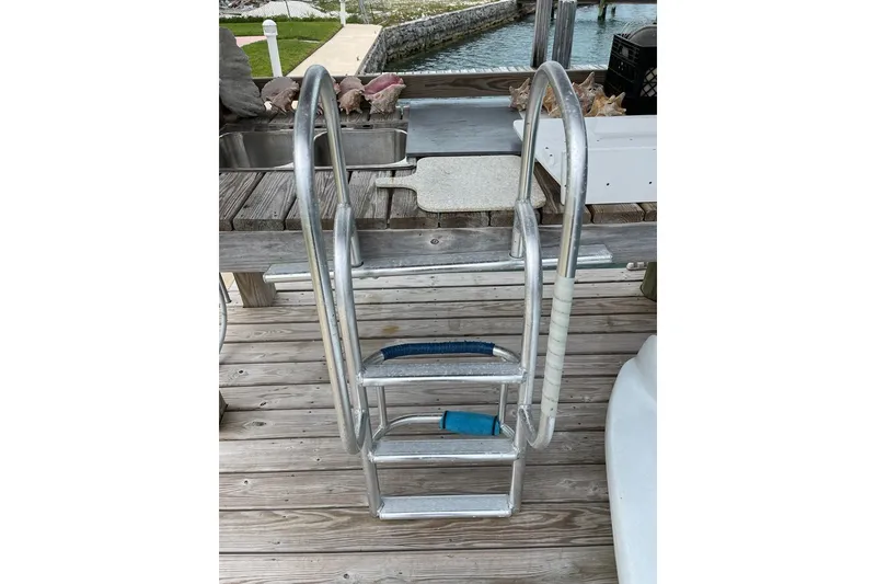 Slide: The Image of Aluminum boat ladder on dock, near water, for 2016 Cobia 344 Center Console. - 20
