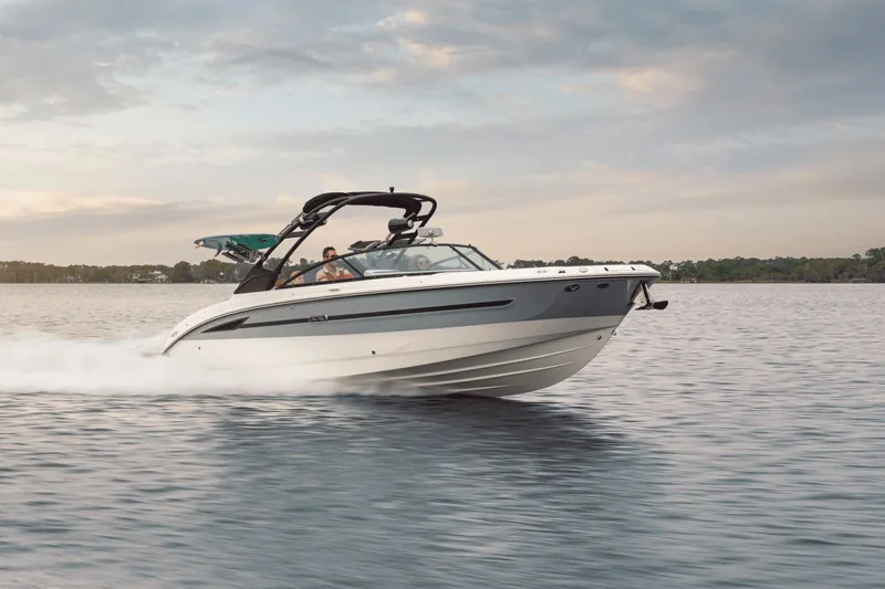 Slide: The Image of A 2025 Sea Ray SDX 270 Surf speeds across the water at sunset. - 3