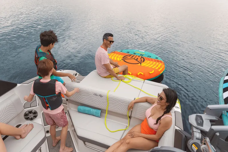 Slide: The Image of Family enjoying leisure time on a Sea Ray SDX 270 Surf boat, with a colorful inflatable tube. - 15