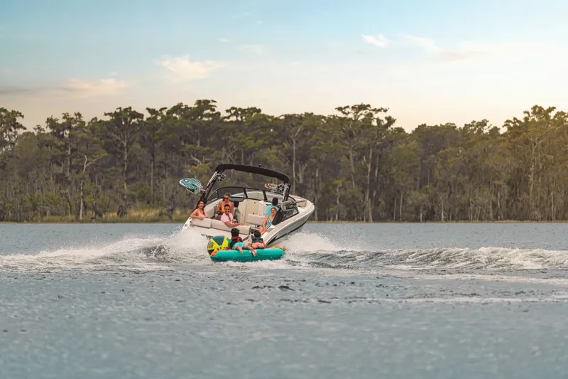 Slide: The Image of A 2025 Sea Ray SDX 270 Surf towing an inflatable tube on a lake. - 24