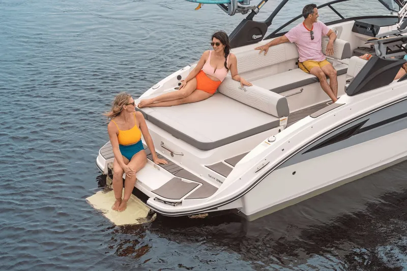 Slide: The Image of Four people relax on a Sea Ray SDX 270 Surf boat on calm water. - 28