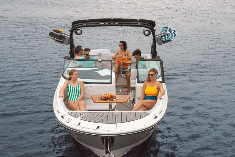 Slide: The Image of A group of people relaxes on a Sea Ray SDX 270 Surf boat on the water. - 6