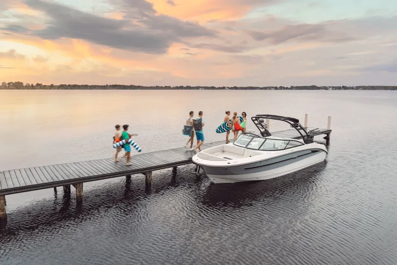 Slide: The Image of A 2025 Sea Ray SDX 270 Surf is docked by a pier. People with towels are approaching. - 39