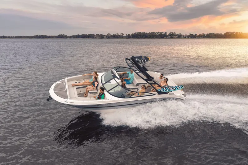 Slide: The Image of A 2025 Sea Ray SDX 270 Surf speeds across the water at sunset. - 4