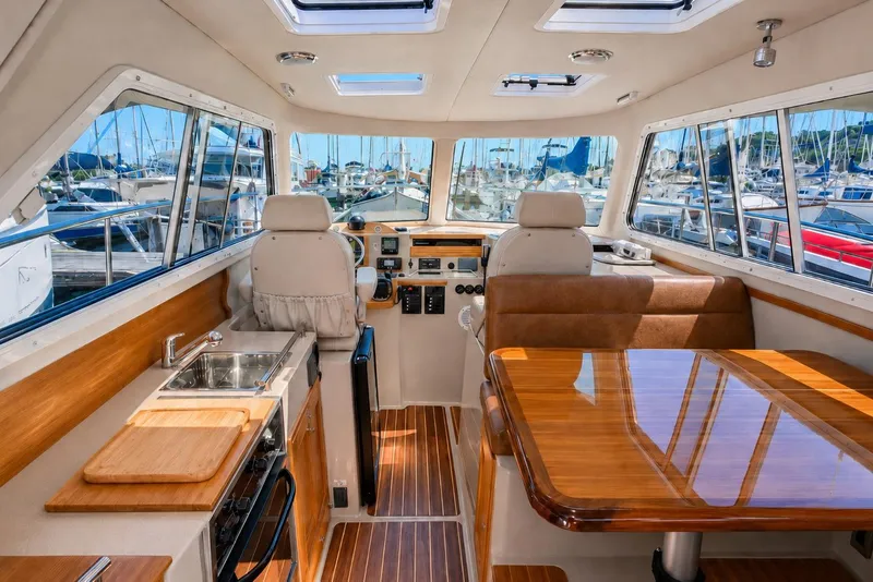Slide: The Image of Interior of 2014 Aspen C100 boat with wood finishes and marina view. - 6