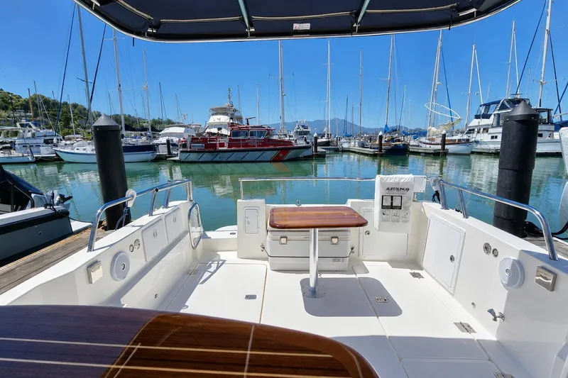 Slide: The Image of Aspen C100 2014 boat interior at marina, surrounded by sailboats and clear blue sky. - 5
