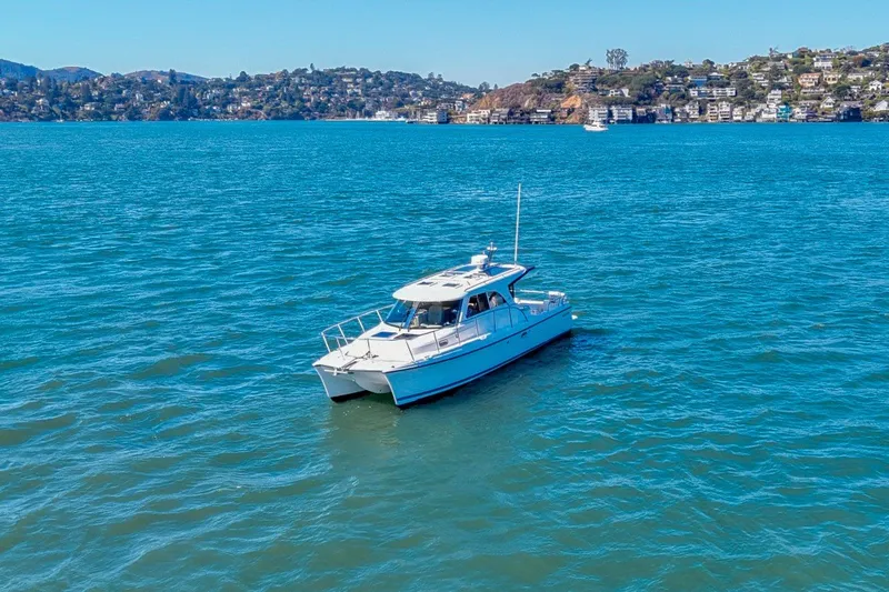 Slide: The Image of A 2014 Aspen C100 boat cruising on a scenic blue lake with hills in the background. - 4