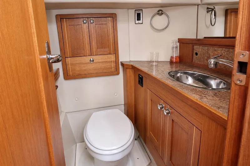 Slide: The Image of Compact bathroom in 2014 Aspen C100 boat with wooden cabinetry and stainless steel sink. - 8