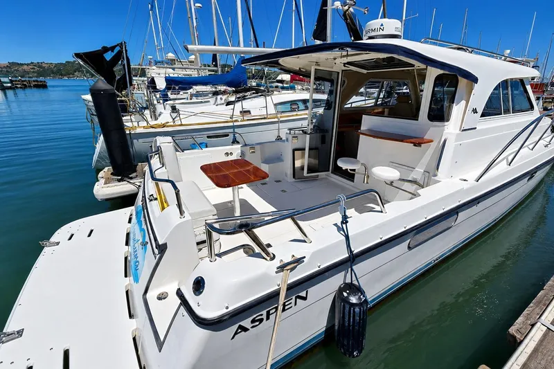 Slide: The Image of Luxury Aspen C100 yacht docked at marina, showcasing sleek design and spacious deck, 2014 model. - 3