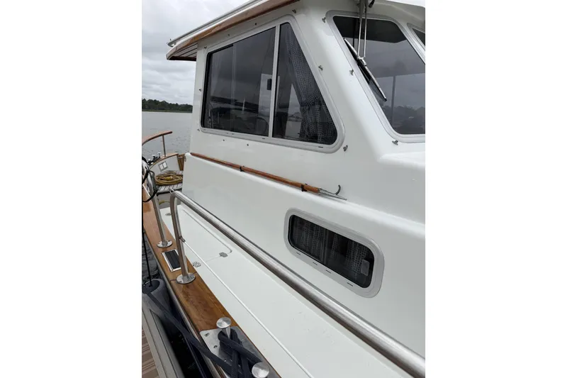 Slide: The Image of 2002 Menorquin 110 boat exterior with white cabin and wooden deck details. - 9