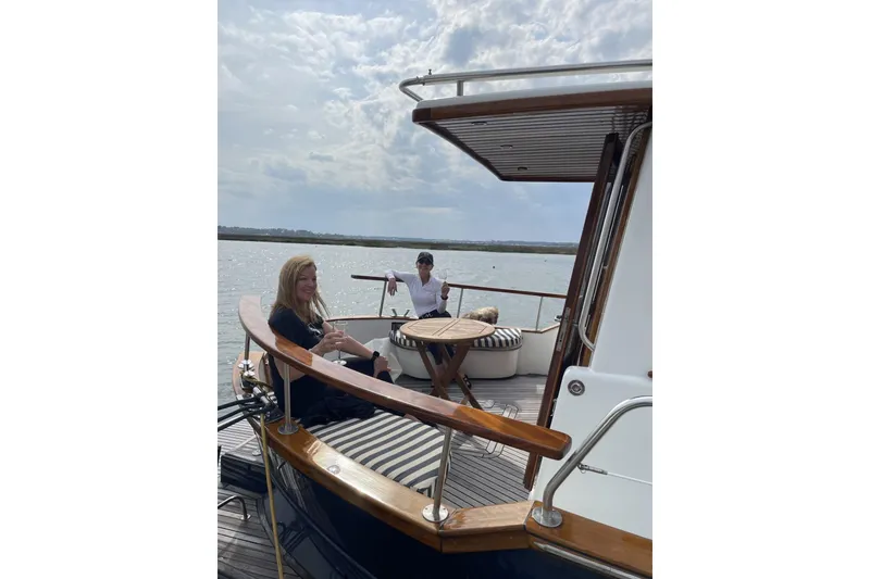 Slide: The Image of People relaxing on a 2002 Menorquin 110 yacht, enjoying a scenic water view. - 6