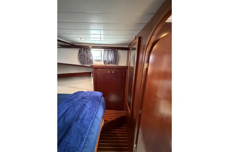 Slide: The Image of Cozy cabin interior of 2002 Menorquin 110 with wooden finishes and blue bedding. - 24
