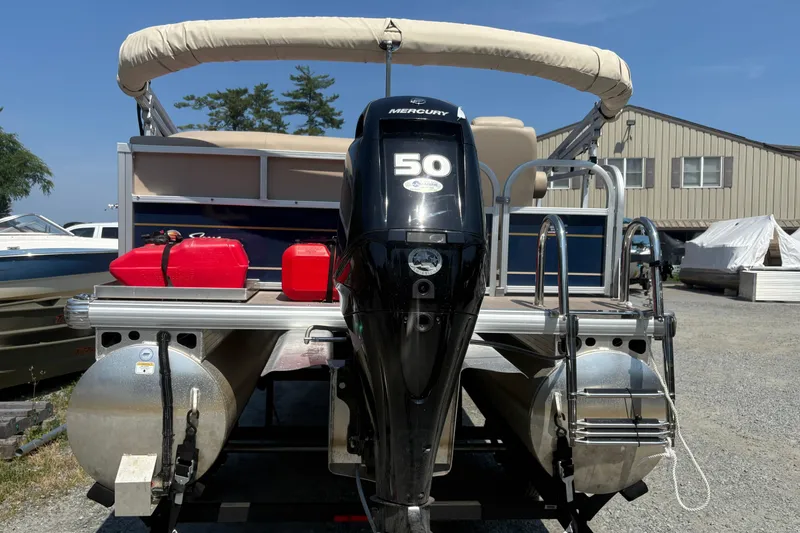 Slide: The Image of 2024 Sun Tracker Bass Buggy 16 DLX pontoon boat with Mercury 50 engine, docked outdoors. - 3