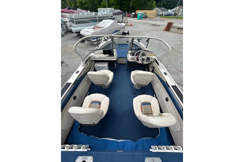 Slide: The Image of 2001 Crestliner 1850 O/B boat interior with seating and steering wheel, parked outdoors. - 3