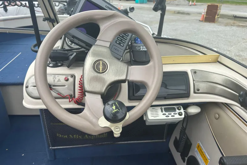 Slide: The Image of Steering wheel and dashboard of a 2001 Crestliner 1850 O/B boat with navigation equipment. - 6