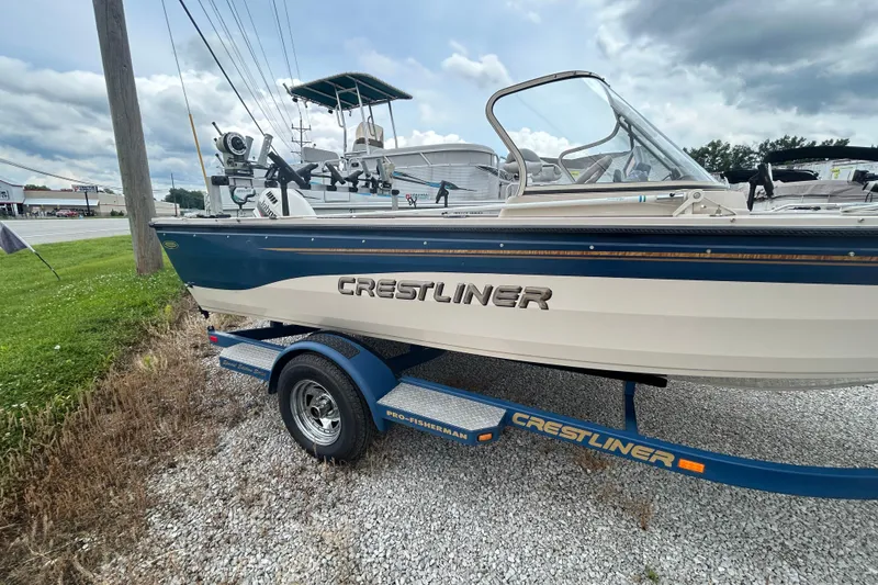 Slide: The Image of 2001 Crestliner 1850 O/B boat on trailer, parked outdoors under cloudy sky. - 8