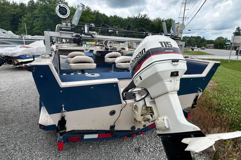 Slide: The Image of 2001 Crestliner 1850 O/B boat with Johnson 115 outboard motor, parked on gravel. - 9