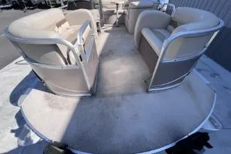 Slide: The Image of 2012 Avalon Tahoe boat interior with beige seating and spacious deck. - 9