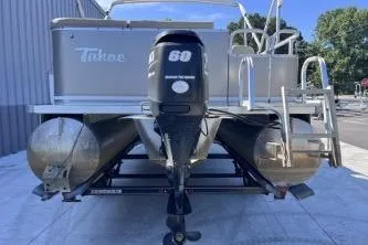 Slide: The Image of 2012 Avalon Tahoe pontoon boat with outboard motor, docked outdoors. - 8