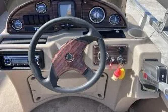 Slide: The Image of Steering console of a 2012 Avalon Tahoe boat with wood accents and gauges. - 17