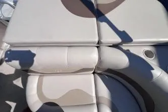 Slide: The Image of 2012 Avalon Tahoe boat seating with beige upholstery and cup holder. - 13