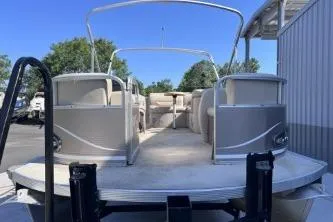 Slide: The Image of 2012 Avalon Tahoe pontoon boat with spacious deck and seating, parked outdoors. - 4