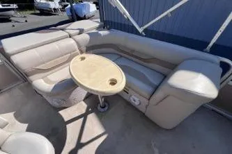 Slide: The Image of 2012 Avalon Tahoe boat interior with beige seating and round table. - 11