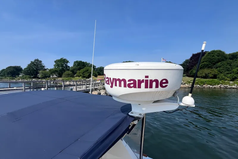 Slide: The Image of 2004 Hunt Yachts Surfhunter 29 with Raymarine radar, docked by a scenic shoreline. - 28