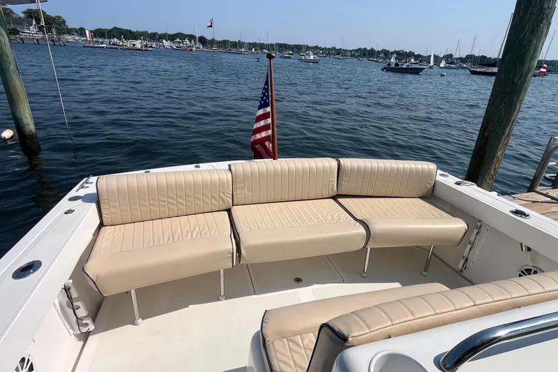 Slide: The Image of 2004 Hunt Yachts Surfhunter 29 with beige seating, docked in a scenic marina. - 8
