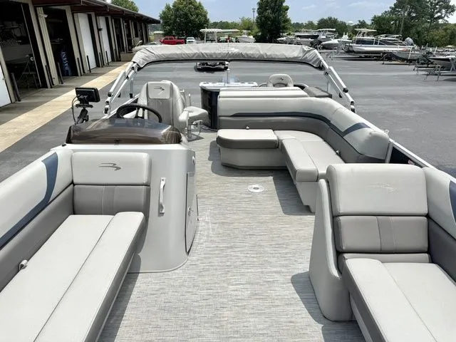 Slide: The Image of The image shows a Bennington pontoon boat with gray upholstery and a spacious deck. - 2