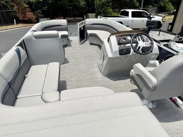 Slide: The Image of The image shows the interior of a Bennington 22 SXSAPG pontoon boat with gray seating and a helm. - 5