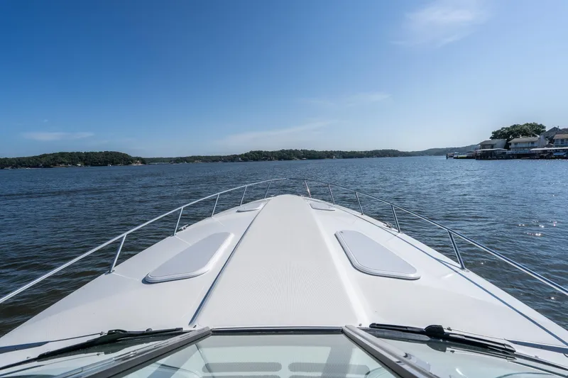 Slide: The Image of 2007 Formula 400 Super Sport boat cruising on a serene lake under a clear blue sky. - 14