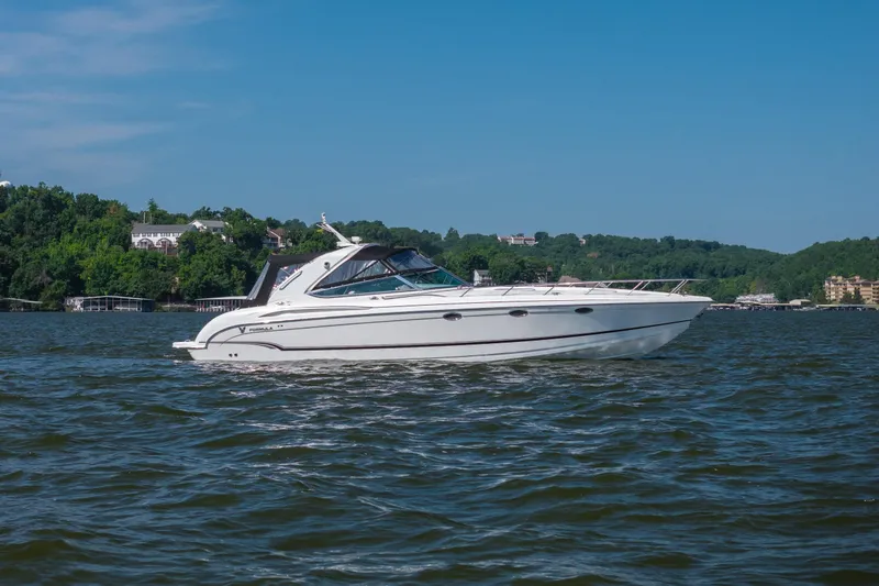 Slide: The Image of 2007 Formula 400 Super Sport boat cruising on a scenic lake with lush green shoreline. - 11
