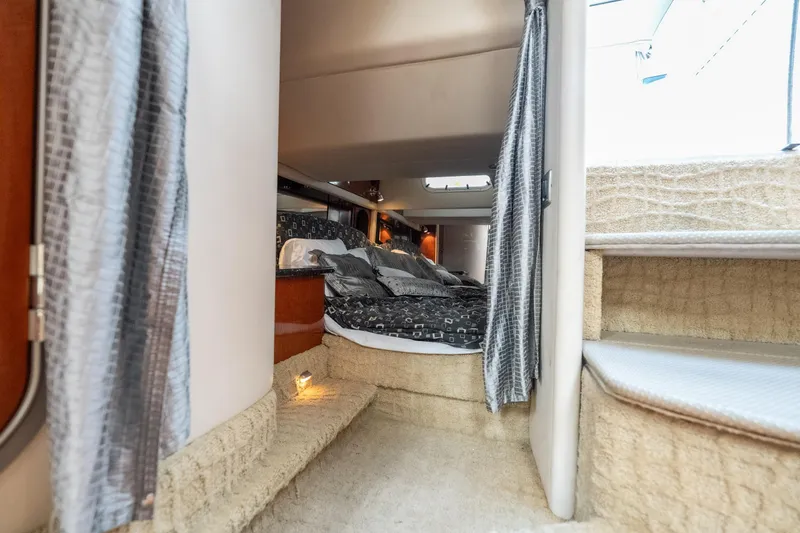 Slide: The Image of Interior cabin of a 2007 Formula 400 Super Sport yacht, featuring cozy bedding and elegant curtains. - 49