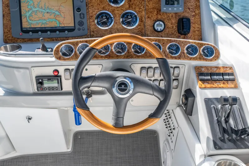 Slide: The Image of 2007 Formula 400 Super Sport boat dashboard with steering wheel and navigation instruments. - 25