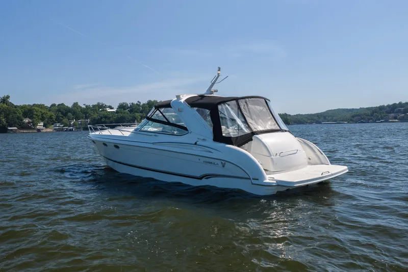 Slide: The Image of 2007 Formula 400 Super Sport boat cruising on a serene lake under a clear blue sky. - 12