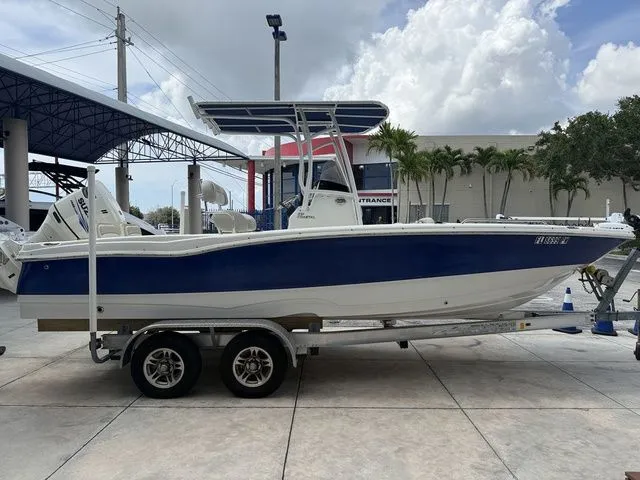 Slide: The Image of A blue and white 2015 NauticStar 231 Coastal on a trailer under a covered area. - 11