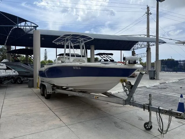 Slide: The Image of A blue and white boat on a trailer in a covered area. - 13