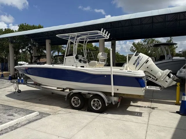 Slide: The Image of A blue and white boat is on a trailer under a covered area. - 17