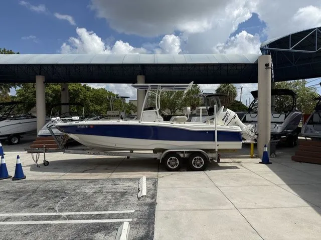 Slide: The Image of A blue and white boat on a trailer in a parking area under a covered section. - 18